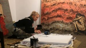 artist dripping paint in her studio