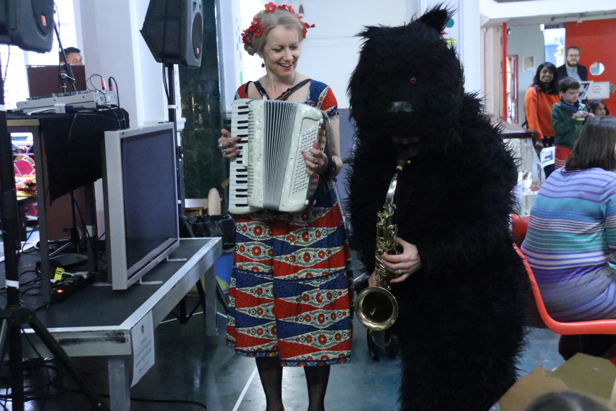 performance: Delpha with accordion next to a man dressed as a bear