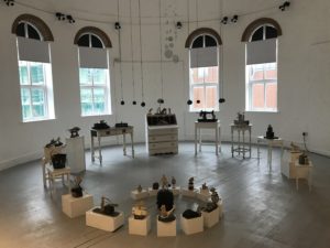 art installation with white furniture poinths and small sculpture at artcore derby