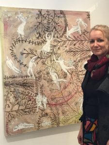 artist with painting at exhibition