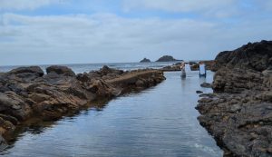 photo of artists Helen Sargeant and Delpha Hudson washing baby clothes at Priest's Cove, Cape Cornwall as art performance