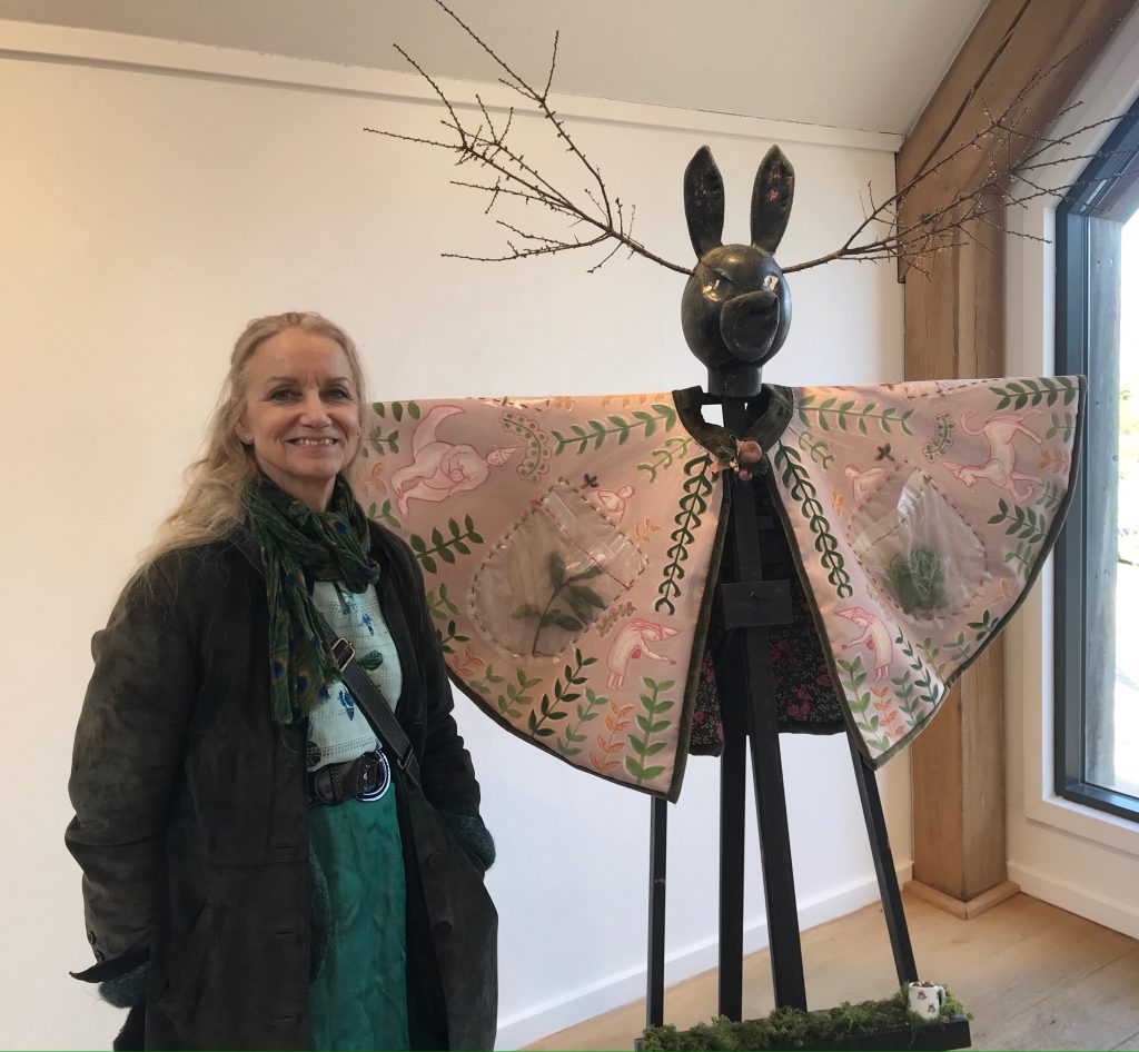 woman artist with ecofeminist sculpture 
