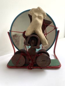 small combinage sculpture with stone ware figure and found objects